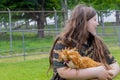 Girl holding a cute padovana chicken outside