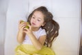 Happy girl holding and eating yellow sweet pear