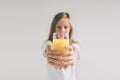 Happy girl holding glass of orange juice isolated on white background. Nerd is wearing glasses Royalty Free Stock Photo
