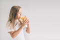 Happy girl holding glass of orange juice isolated on white background. Nerd is wearing glasses Royalty Free Stock Photo