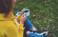 Happy girl holding in hands cup of hot tea on green grass in outdoors nature park top view, beautiful woman hipster enjoy drinking Royalty Free Stock Photo