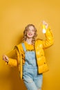 Happy girl holding light bulb on yellow background Royalty Free Stock Photo