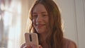 Happy girl holding mobile phone in golden sunlight closeup. Teenager in love