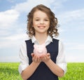 Happy girl holding piggy bank on palms Royalty Free Stock Photo