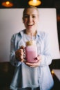 Happy girl is holding stylized mason jar cup of pink coffee with marshmallow and decoration. Milk shake, cocktail. Unicorn coffee, Royalty Free Stock Photo