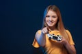 Happy girl holding video game joystick pointing finger at you