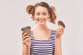 Happy girl holds donut and chews mouth full Royalty Free Stock Photo