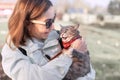 girl holds pet in her arms and smiles looking at her favorite cute cat. Walking with a pet in the nearest city Park. Concept