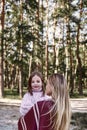 Happy, girl huggs her beautiful mother near forest. Close-up