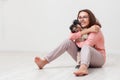 Happy girl hugs a dog. child with little dogs playing at home. A teenager with a puppy sits on the floor on a white background