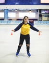 Happy girl ice skating on the rink by herself Royalty Free Stock Photo