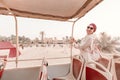 Happy girl in an Indian headdress travels on the roof of a bus in a natural and historical Park. Desert Safari and adventure Royalty Free Stock Photo