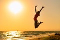 Happy girl jumping on the beach against the background of the sea and sunset. Royalty Free Stock Photo