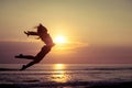 Happy girl jumping on the beach at the sunset time Royalty Free Stock Photo