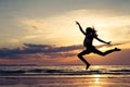 Happy girl jumping on the beach at the sunset time Royalty Free Stock Photo
