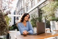 Happy girl with laptop is chatting with her friends and family outdoor in cafe. Confident business woman is chatting Royalty Free Stock Photo