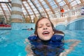 Happy girl in lifejacket in the clear blue water