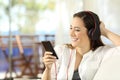 Happy girl listening to music in a beach apartment Royalty Free Stock Photo