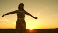 Happy girl listening to music and dancing in rays of a beautiful sunset against the sky. young girl in headphones and Royalty Free Stock Photo