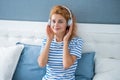 Happy girl listening to music relaxing on bed, music. Resting girl enjoying music Royalty Free Stock Photo