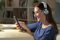 Happy girl listens music on phone at night at home Royalty Free Stock Photo