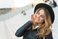 Happy girl with long blond hair, hairstyle, in paris, france. Girl in black hat smile outdoor, fashion. Beauty, look, makeup. Fash Royalty Free Stock Photo