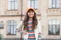 Happy girl with long curly hair. pretty child smiling outdoor. kid beauty and fashion. cheerful school girl wear cap Royalty Free Stock Photo