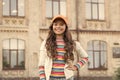 happy girl with long curly hair. pretty child smiling outdoor. kid beauty and fashion. cheerful school girl wear cap Royalty Free Stock Photo