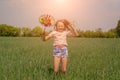 Happy girl with long hair holding a colored windmill toy in her hands and jumping Royalty Free Stock Photo
