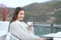 Happy girl looks away holding coffee mug in a terrace Royalty Free Stock Photo