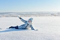 Happy girl lying down on the snow in winter Royalty Free Stock Photo