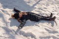 Happy girl lying down on the snow in winter. The girl lies in the snow in winter Royalty Free Stock Photo