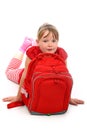 Happy girl lying on floor behind her school bag Royalty Free Stock Photo