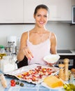 Happy girl making pizza with ham Royalty Free Stock Photo