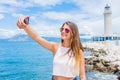 Happy girl making selfie in front of Patras lighthouse, Peloponnese, Greece. Royalty Free Stock Photo
