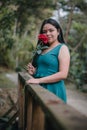 Happy girl in the middle of a bridge with rose in hands