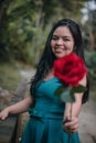 Happy girl in the middle of a bridge with rose in hands