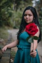 Happy girl in the middle of a bridge with rose in hands