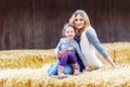 Happy girl and mother having fun with hay on a farm Royalty Free Stock Photo
