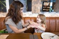 Happy girl and mother in restaurant playing with hands Royalty Free Stock Photo