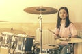 Happy girl in music therapy by playing drum kit on music room. Beautiful young girl drummer with drumsticks playing Royalty Free Stock Photo
