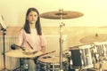 Happy girl in music therapy by playing drum kit on music room. Beautiful young girl drummer with drumsticks playing Royalty Free Stock Photo