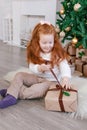 Happy girl opening Christmas presents at home photo Royalty Free Stock Photo