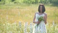 Happy girl outdoor in a field with flowers in nature. girl in a field smiling woman holding a bouquet of flowers Royalty Free Stock Photo