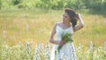 Happy girl outdoor in a field with flowers in nature. girl in a field smiling woman holding a bouquet of flowers Royalty Free Stock Photo