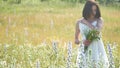 Happy girl outdoor in a field with flowers in nature. girl in a field smiling woman holding a bouquet of flowers Royalty Free Stock Photo