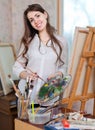 Happy girl paints on canvas with oil colors Royalty Free Stock Photo