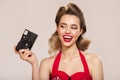 Happy girl in pin-up style holds retro camera in her hand Royalty Free Stock Photo