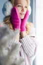 Happy girl in pink mittens and fur hat