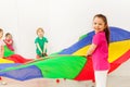 Happy girl playing with colorful parachute in gym Royalty Free Stock Photo